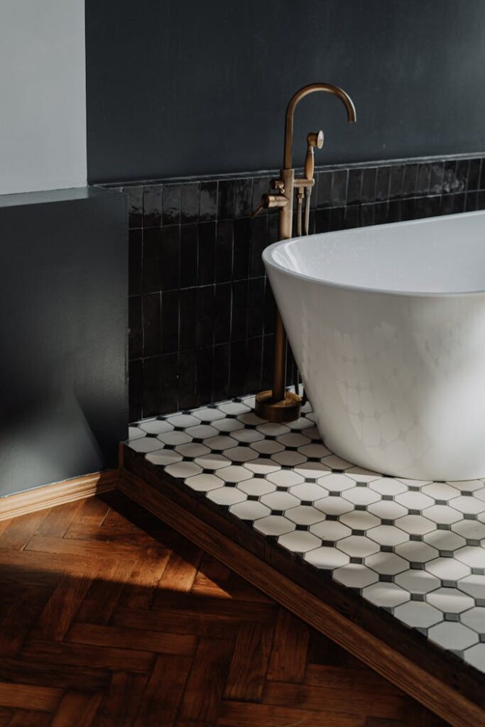 pexels-photo-4154987 Luxury bathroom featuring a white bathtub with brass fixtures and stylish tiled flooring.